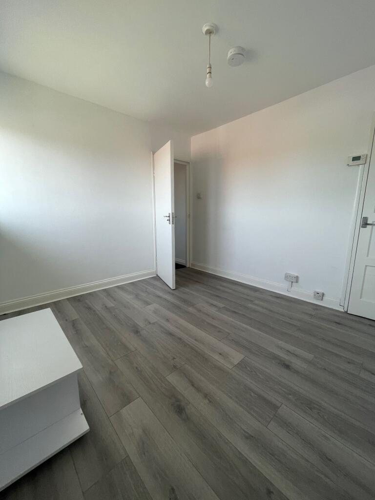 A clean and freshly painted empty room with lig...