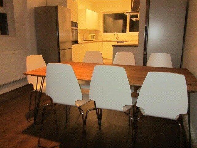 Modern kitchen with a large wooden dining table...