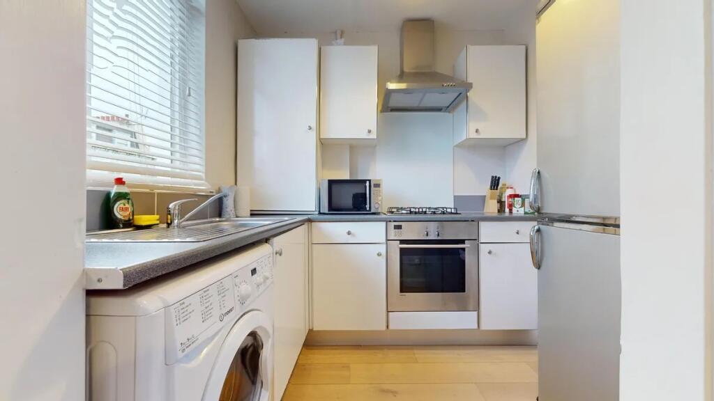 Bright and modern kitchen featuring sleek white...