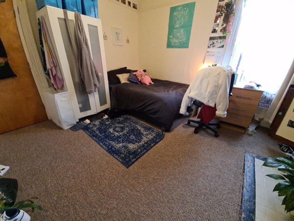 A cozy single bedroom featuring a comfortable b...