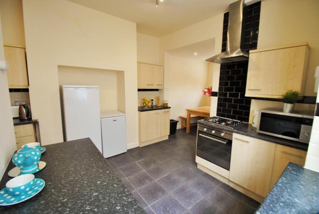 Bright, modern kitchen with integrated oven, am...