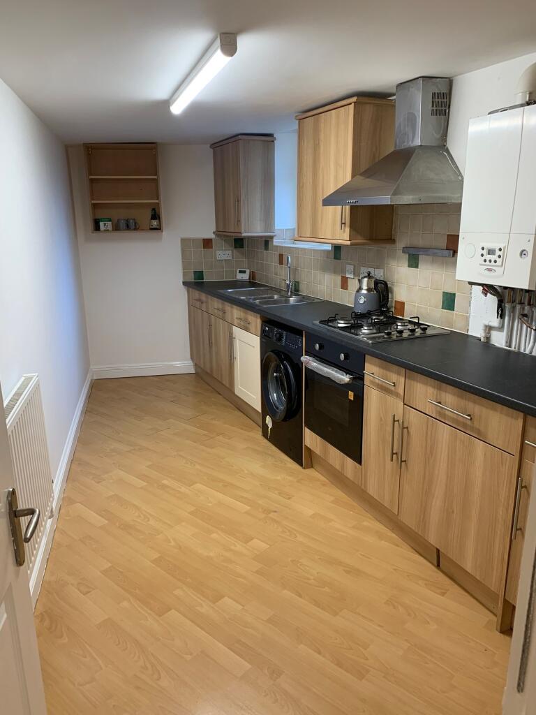 A modern kitchen featuring wood-effect cabinetr...