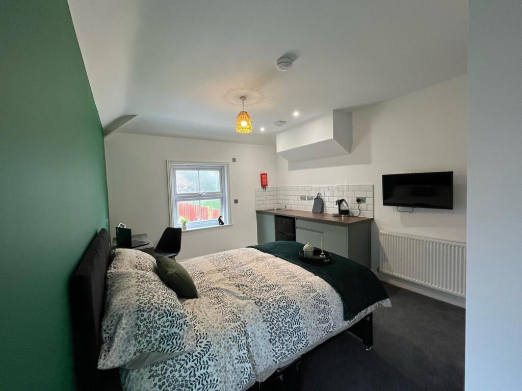 A stylish double bedroom featuring a cozy bed w...