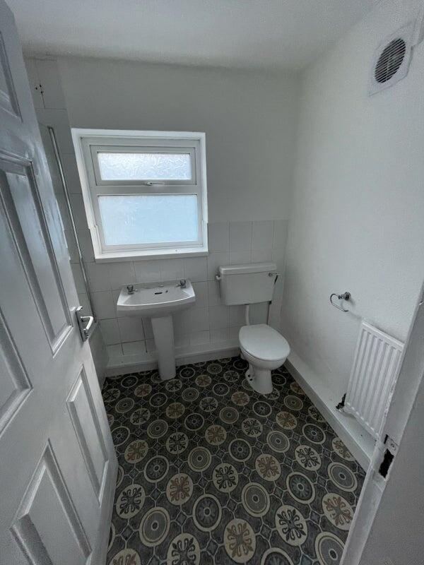A clean and functional bathroom with a patterne...