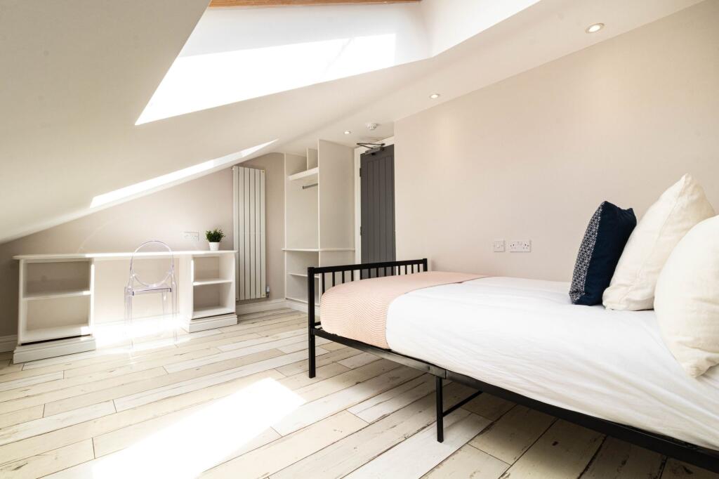 Bright and airy bedroom featuring a large bed w...