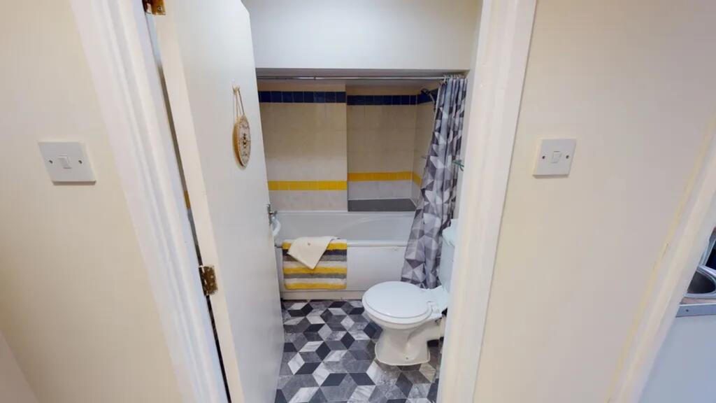 A tidy and functional bathroom featuring a bath...