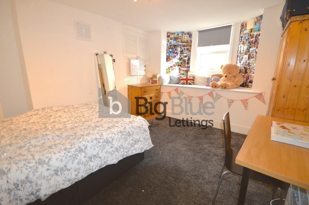 A cozy single bedroom featuring a comfortable b...