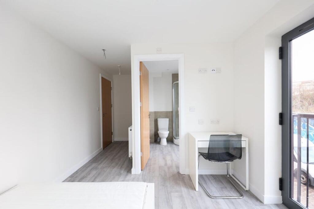 A bright and tidy double bedroom featuring a wo...