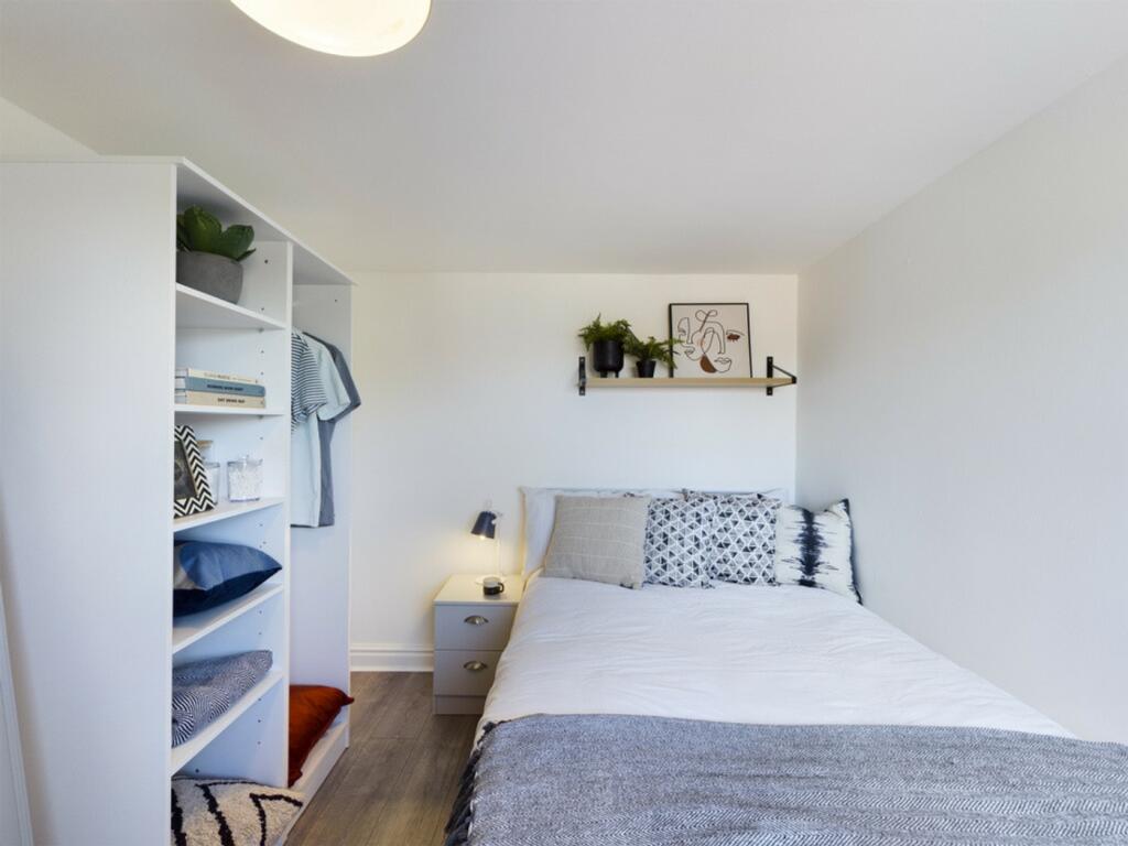 A bright and tidy double bedroom featuring styl...