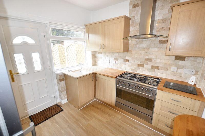 Bright modern kitchen featuring light wood cabi...