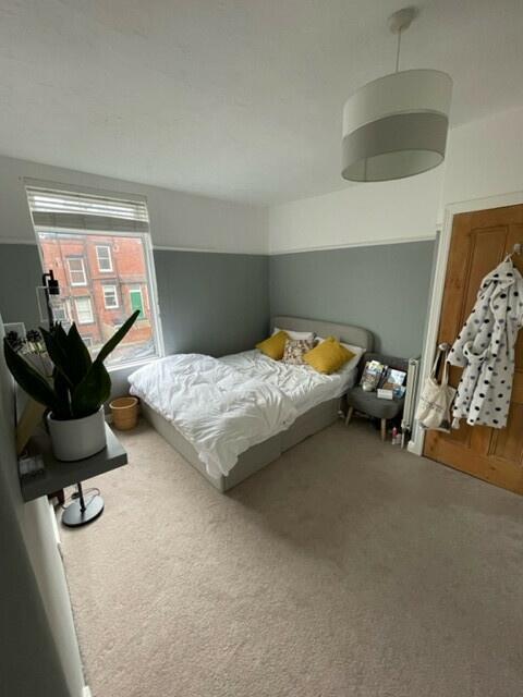 A spacious, well-lit master bedroom featuring a...