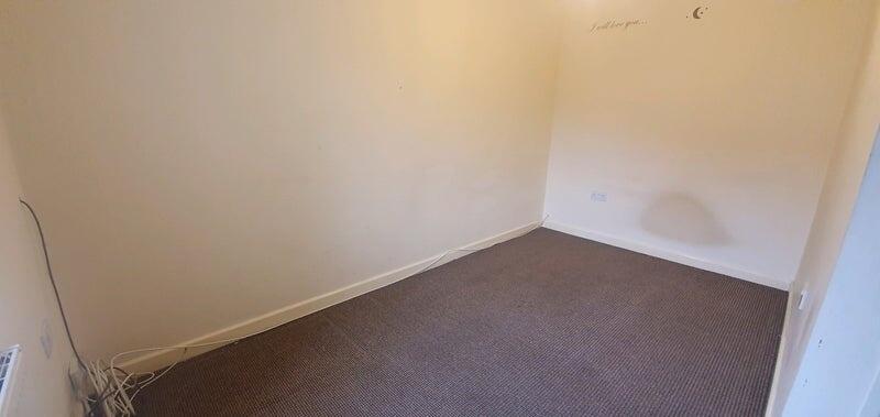 A clean, empty room with neutral walls and a ca...