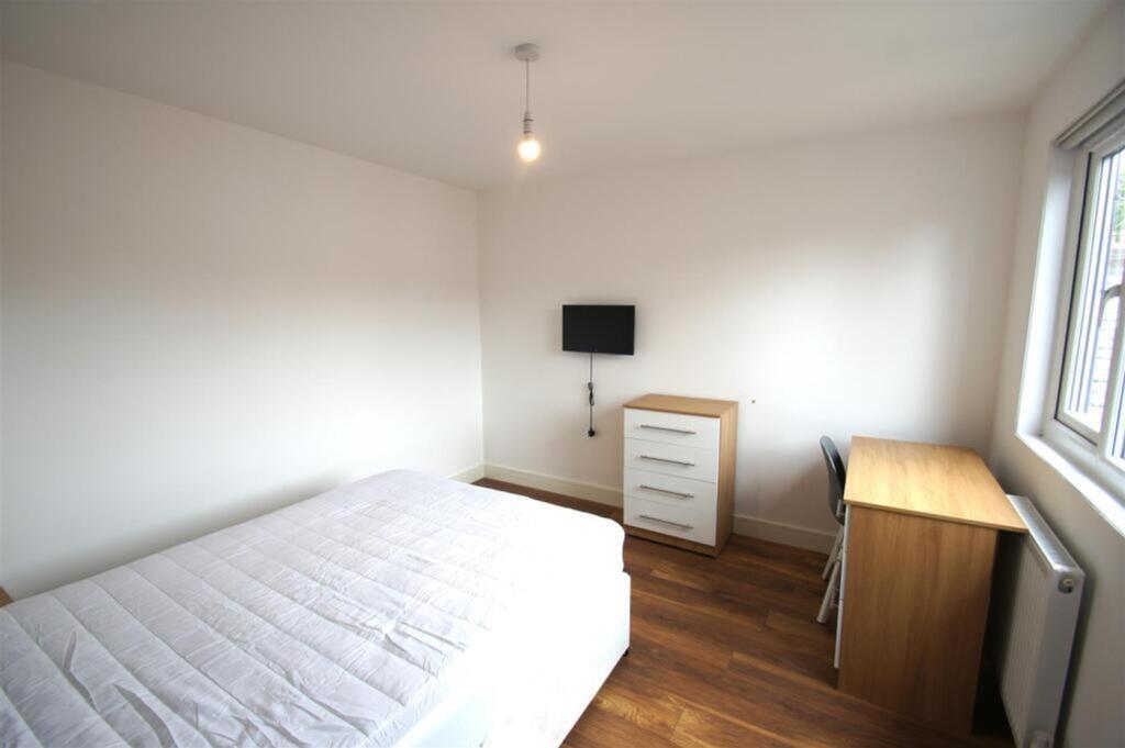 A spacious double bedroom featuring a comfortab...