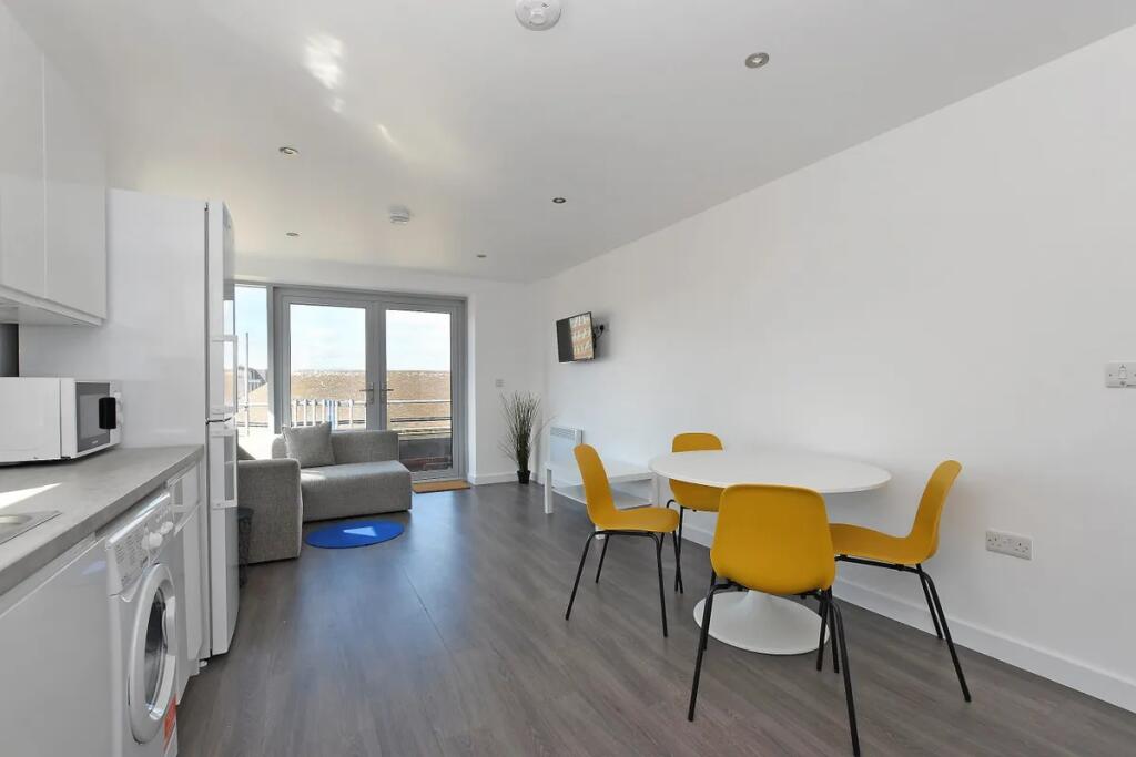 Bright and modern living room featuring a compa...