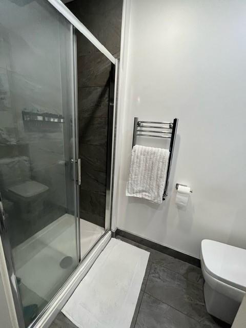 Modern bathroom with a glass-enclosed shower, w...