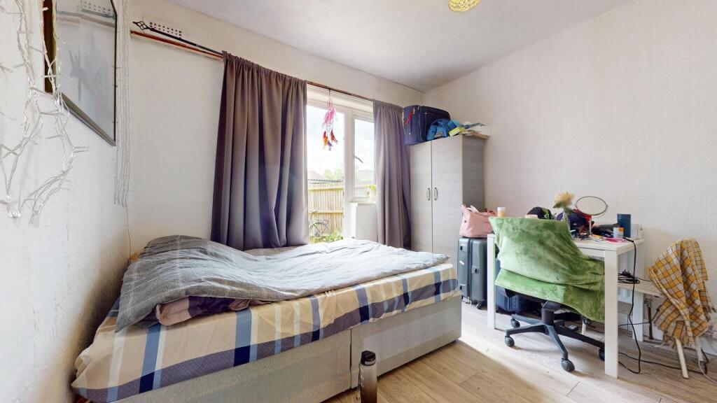 A neat and well-lit bedroom with a comfortable ...