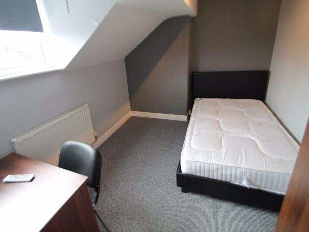 A clean and well-lit single bedroom featuring a...