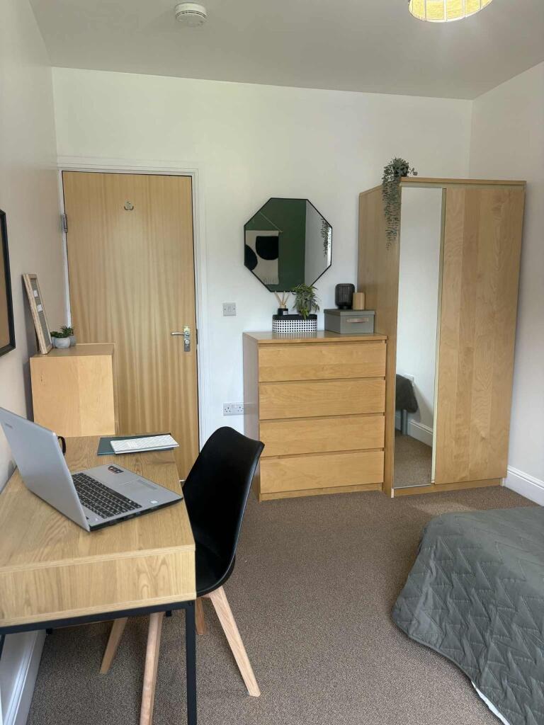 A tidy, well-organized single bedroom featuring...