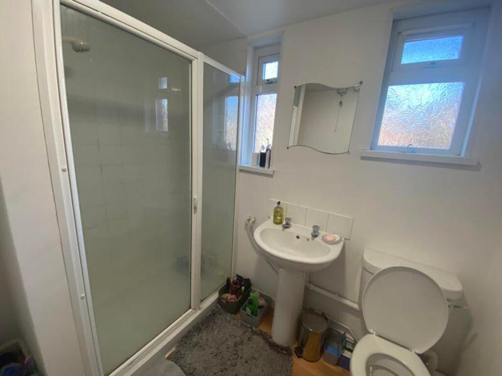 A bright and tidy bathroom featuring a shower a...