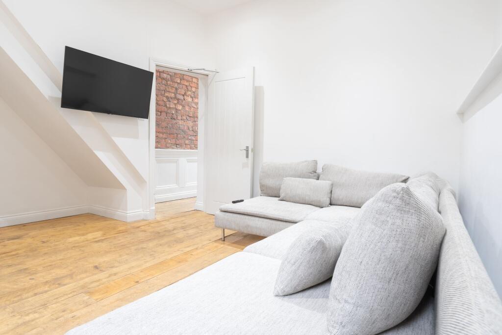 Bright and modern living room featuring a large...