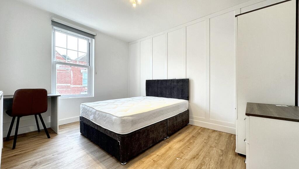 Bright and spacious double bedroom featuring a ...