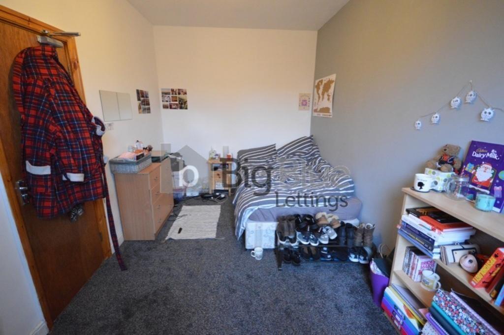 A cozy single bedroom featuring a neatly made b...