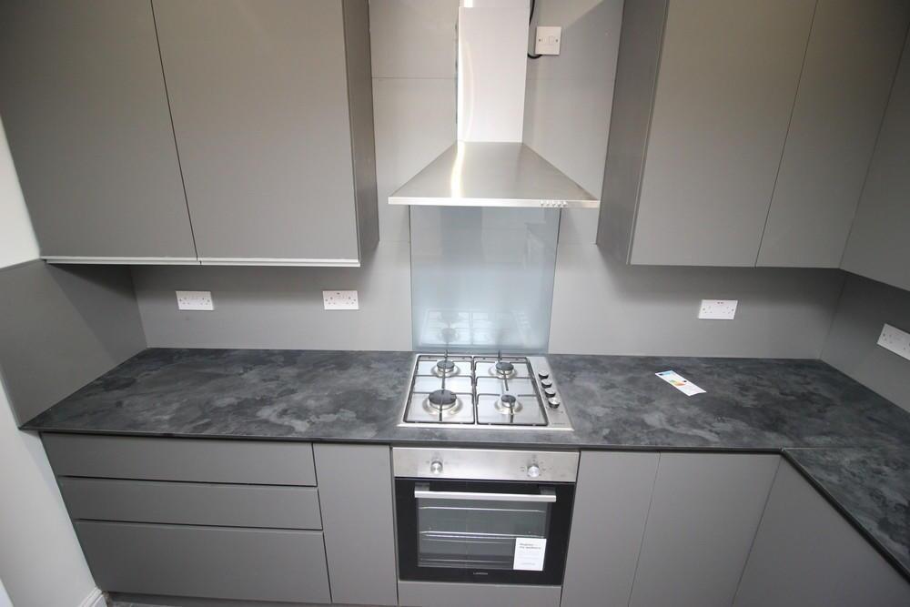 Modern kitchen featuring sleek grey cabinetry a...
