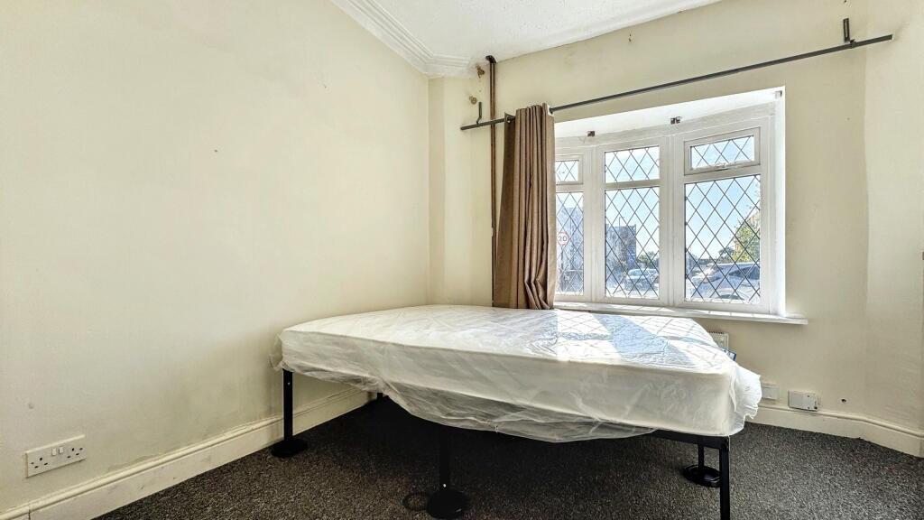 A neat and bright single bedroom featuring a wi...