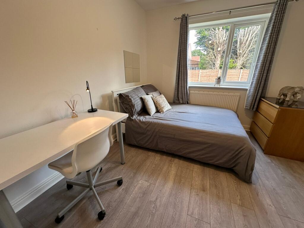 Spacious double bedroom featuring large windows...