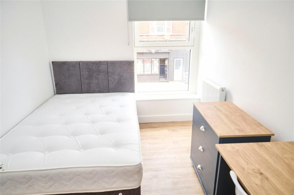 A bright and clean single bedroom featuring a c...