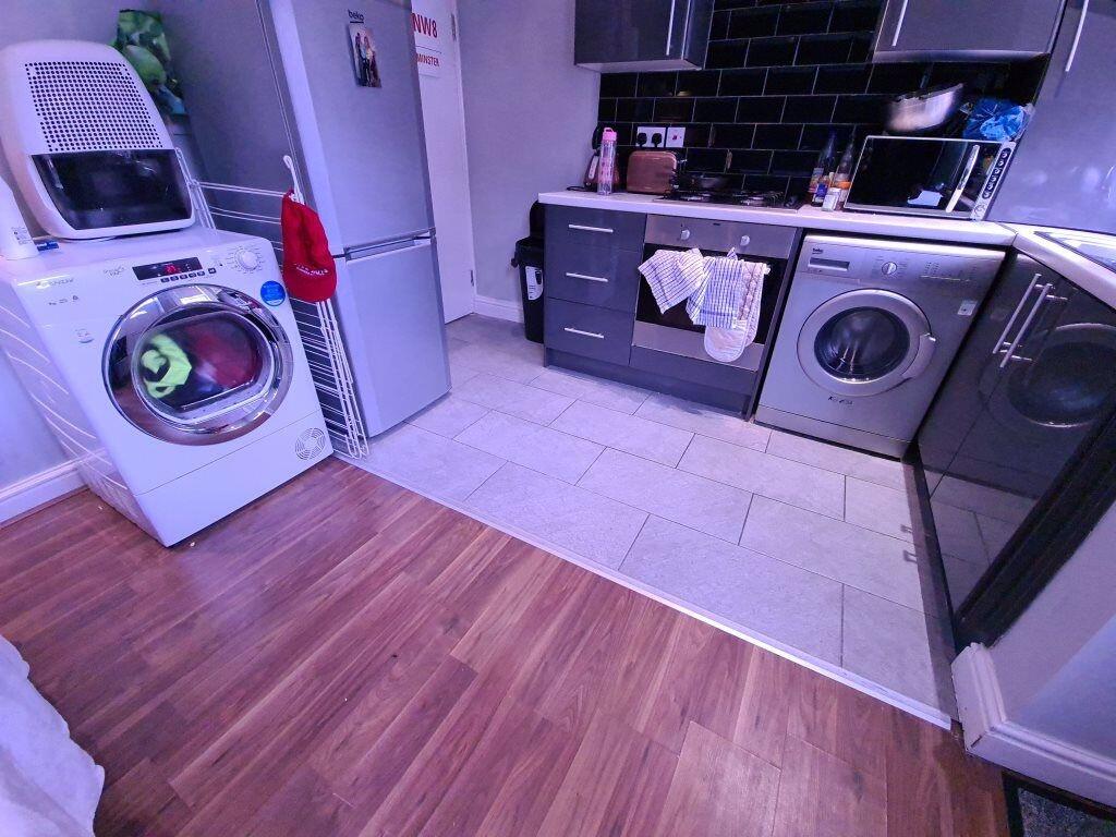 A modern kitchen featuring sleek black cabinetr...