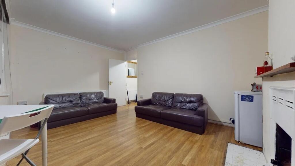 A simple living room featuring two dark leather...