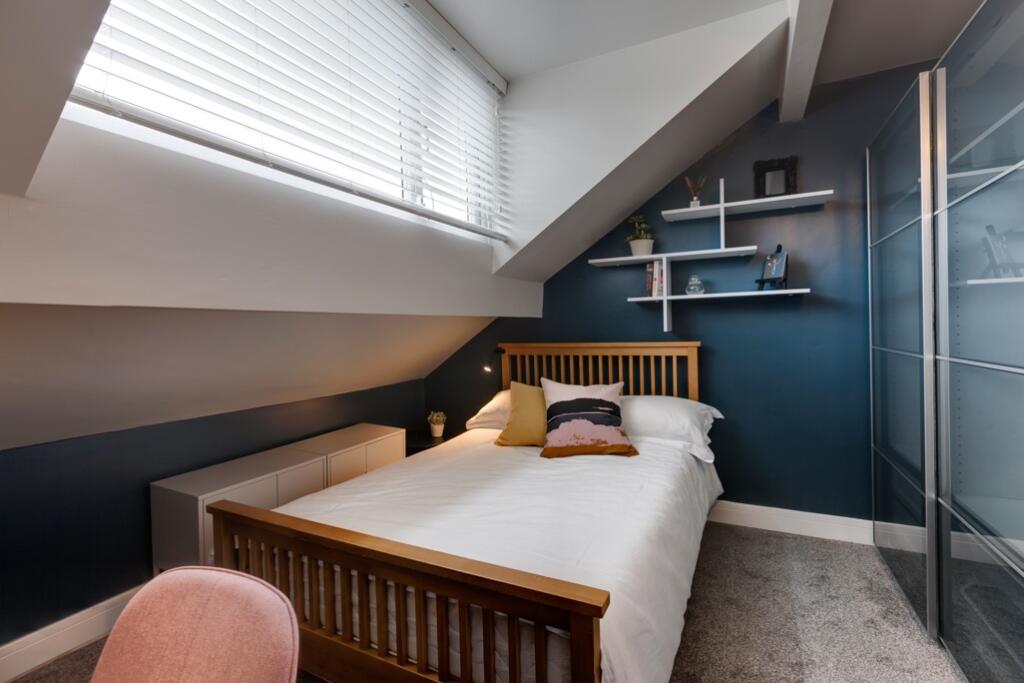 A cozy and well-maintained bedroom with a woode...