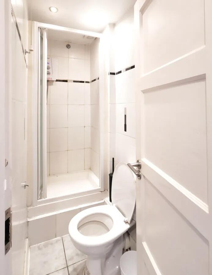 A bright and clean bathroom featuring a white t...