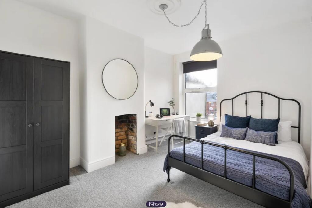 A bright and stylish double bedroom featuring a...
