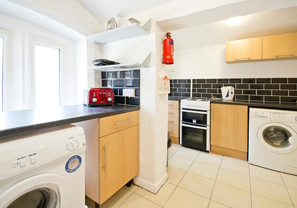 A bright and tidy kitchenette equipped with mod...