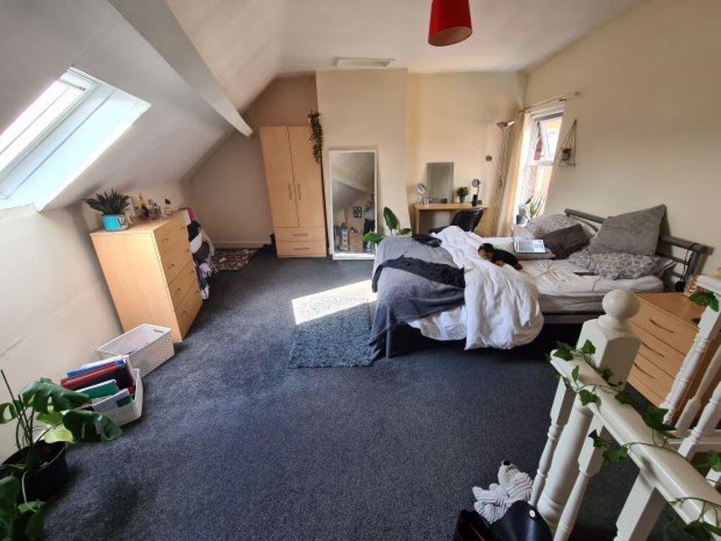 A cozy bedroom with a large bed, some furniture...
