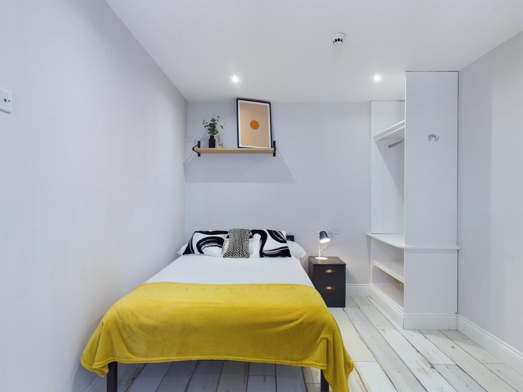 A bright and tidy master bedroom featuring a do...