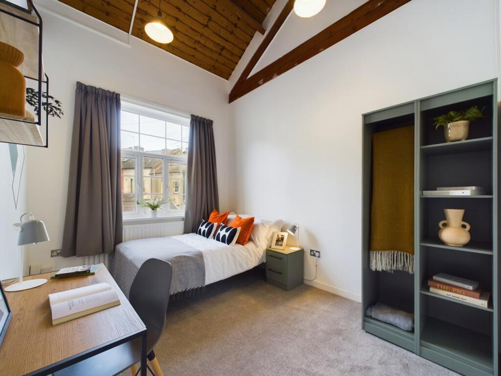 A bright and inviting double bedroom with styli...