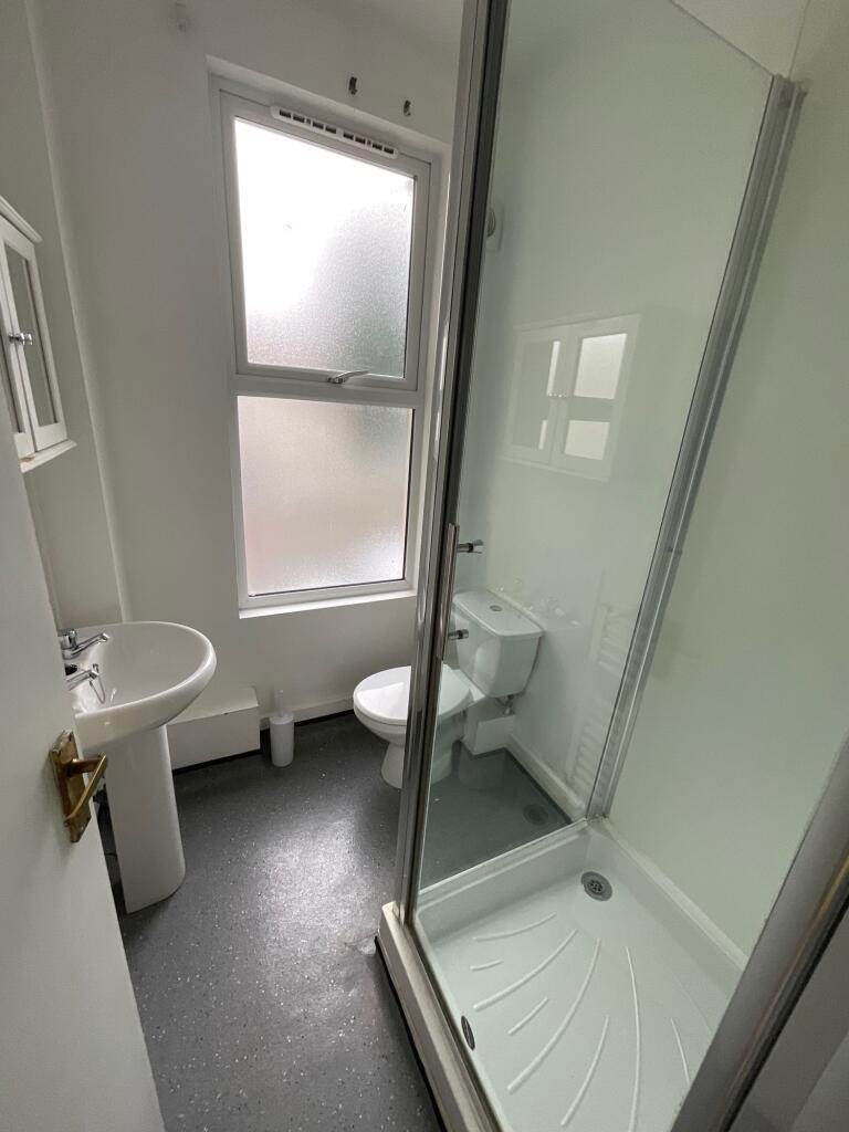 Bright and clean bathroom featuring a modern sh...