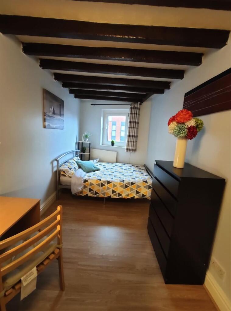 Cozy single bedroom featuring a comfortable bed...