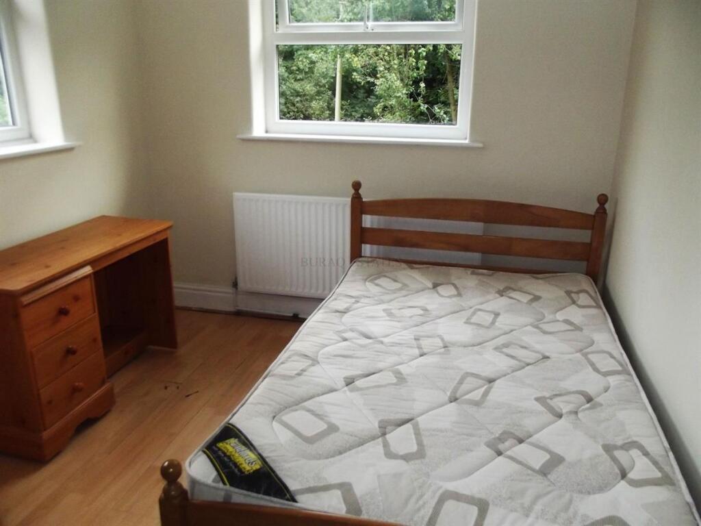Bright, simply furnished bedroom with a single ...