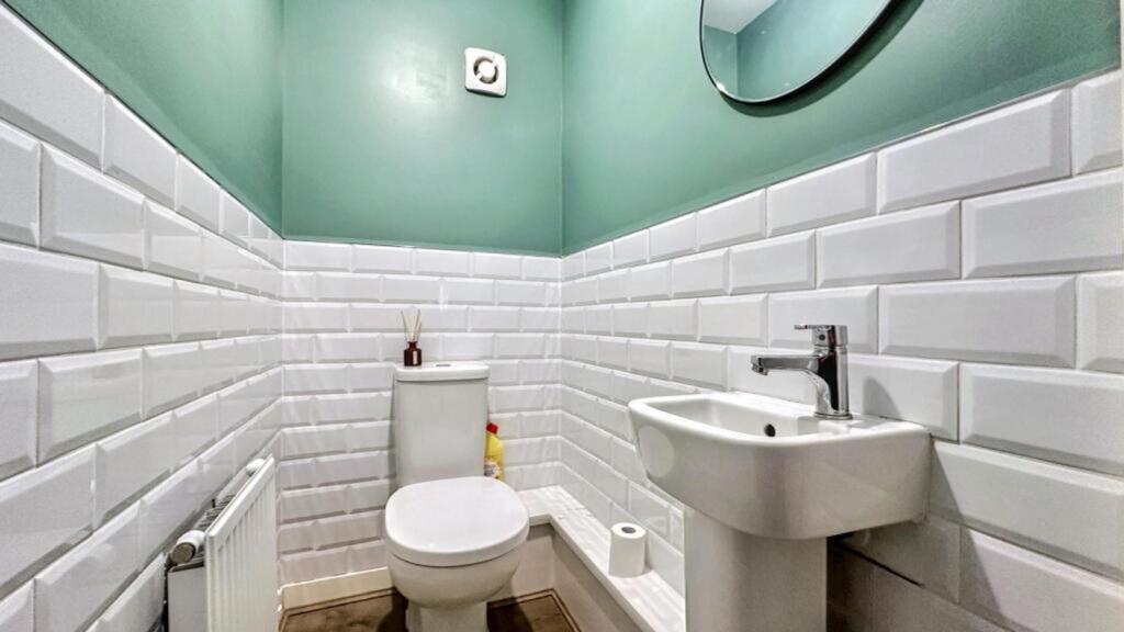 Modern bathroom featuring stylish white tiles a...