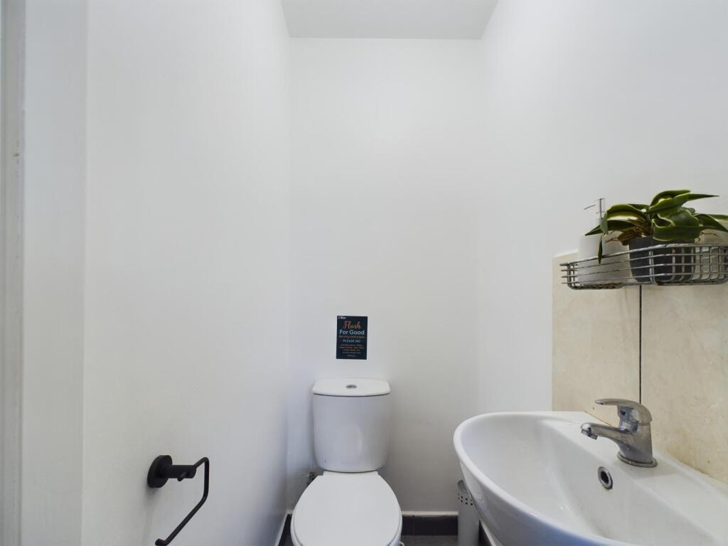 A clean and tidy single toilet with modern fixt...