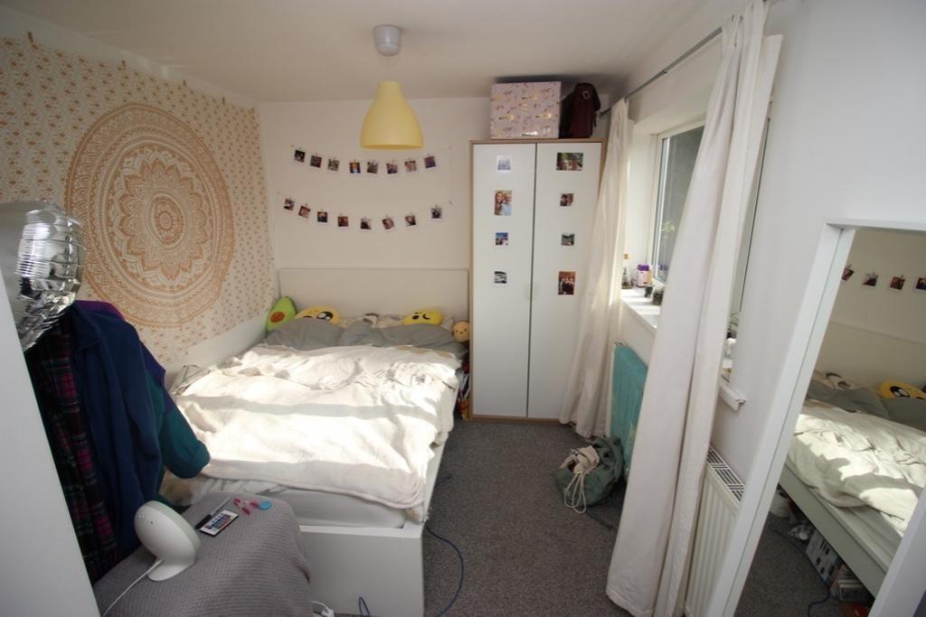 Cozy and well-kept single bedroom featuring a c...
