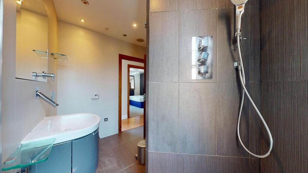 A modern bathroom featuring sleek grey tiles an...