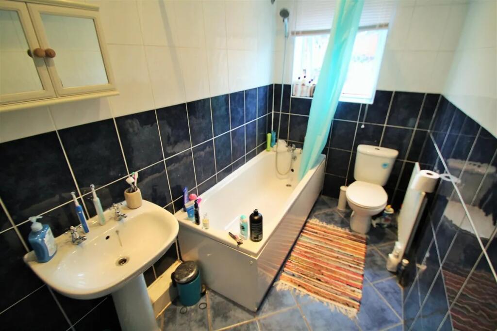A well-maintained bathroom featuring a bathtub ...