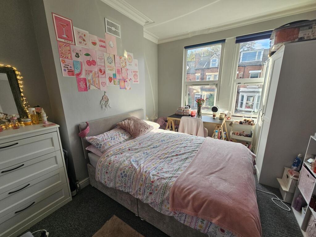 Bright and cozy bedroom featuring a comfortable...