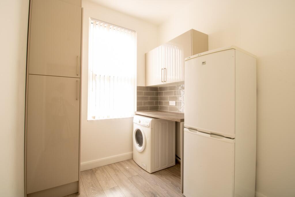 A compact and tidy kitchen with a washing machi...