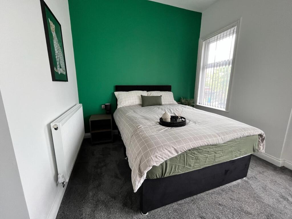 This inviting double bedroom features a modern ...
